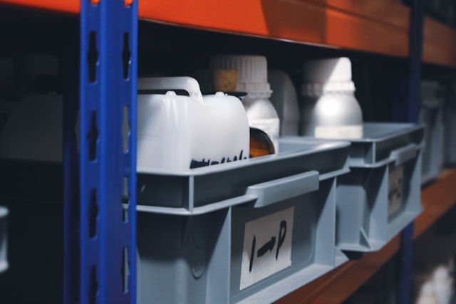 Organized storage bins on a shelf with labeled containers